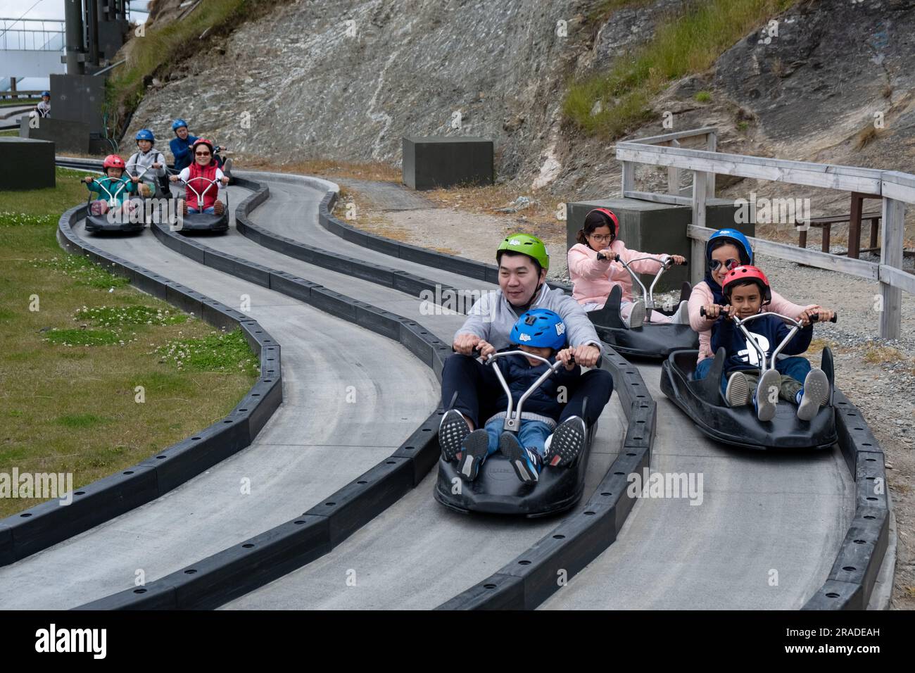 Tourists enjoy the Skyline Luge on Bob's Peak above Queenstown in New Zealand South Island. Photo: Rob Watkins Stock Photo