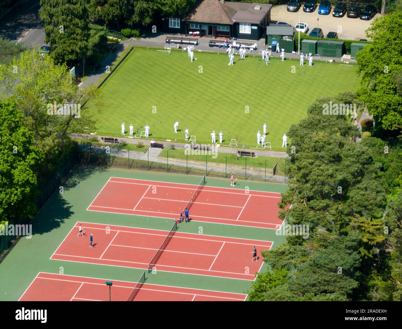 Aerial view of an outdoor tennis court next to a bowling green in the