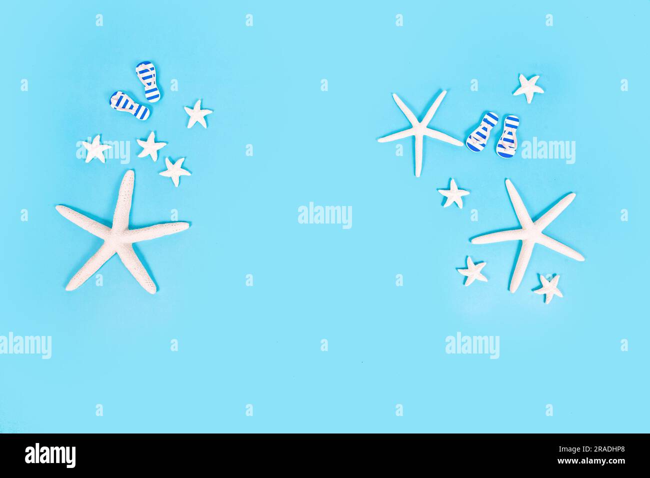 Simple summer banner with white starfish and sandals on blue background Stock Photo