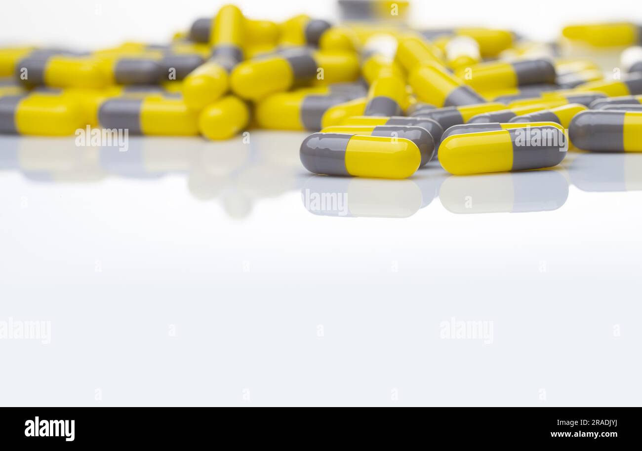 Yellow and gray probiotic capsule pill on white background