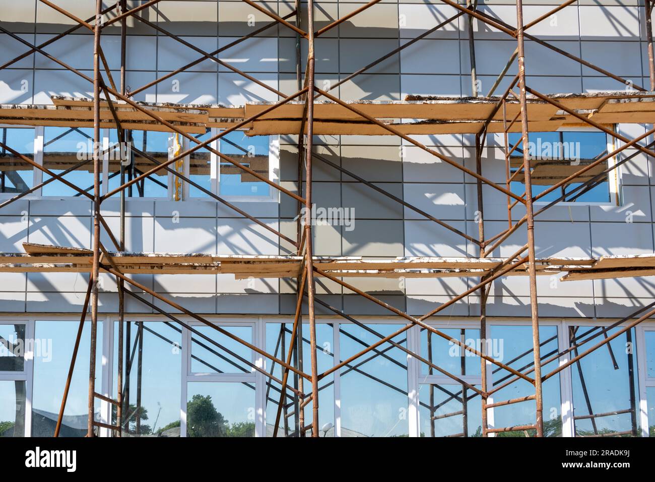 Building under construction. Fragment of scaffolding against house wall. Residential houses under construction. Scaffolding on building wall on constr Stock Photo