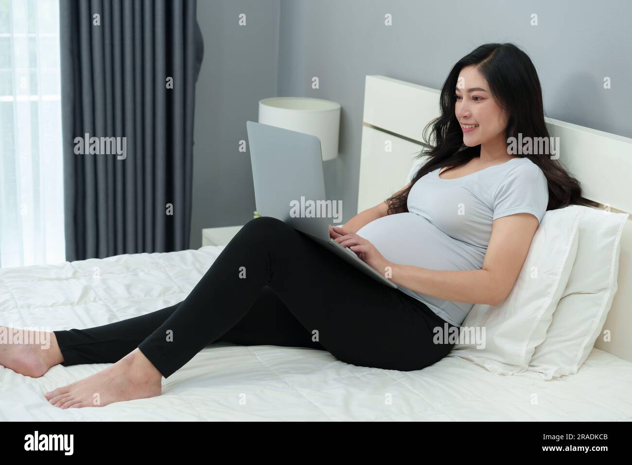 pregnant woman using laptop computer on a bed Stock Photo Alamy