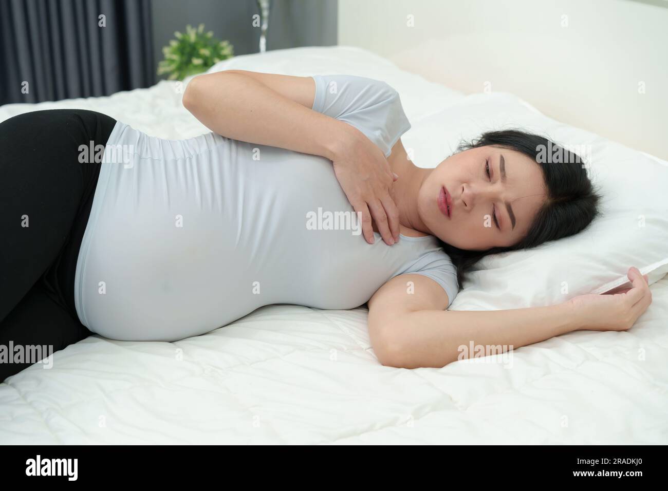 pregnant woman feeling nauseous on a bed Stock Photo Alamy