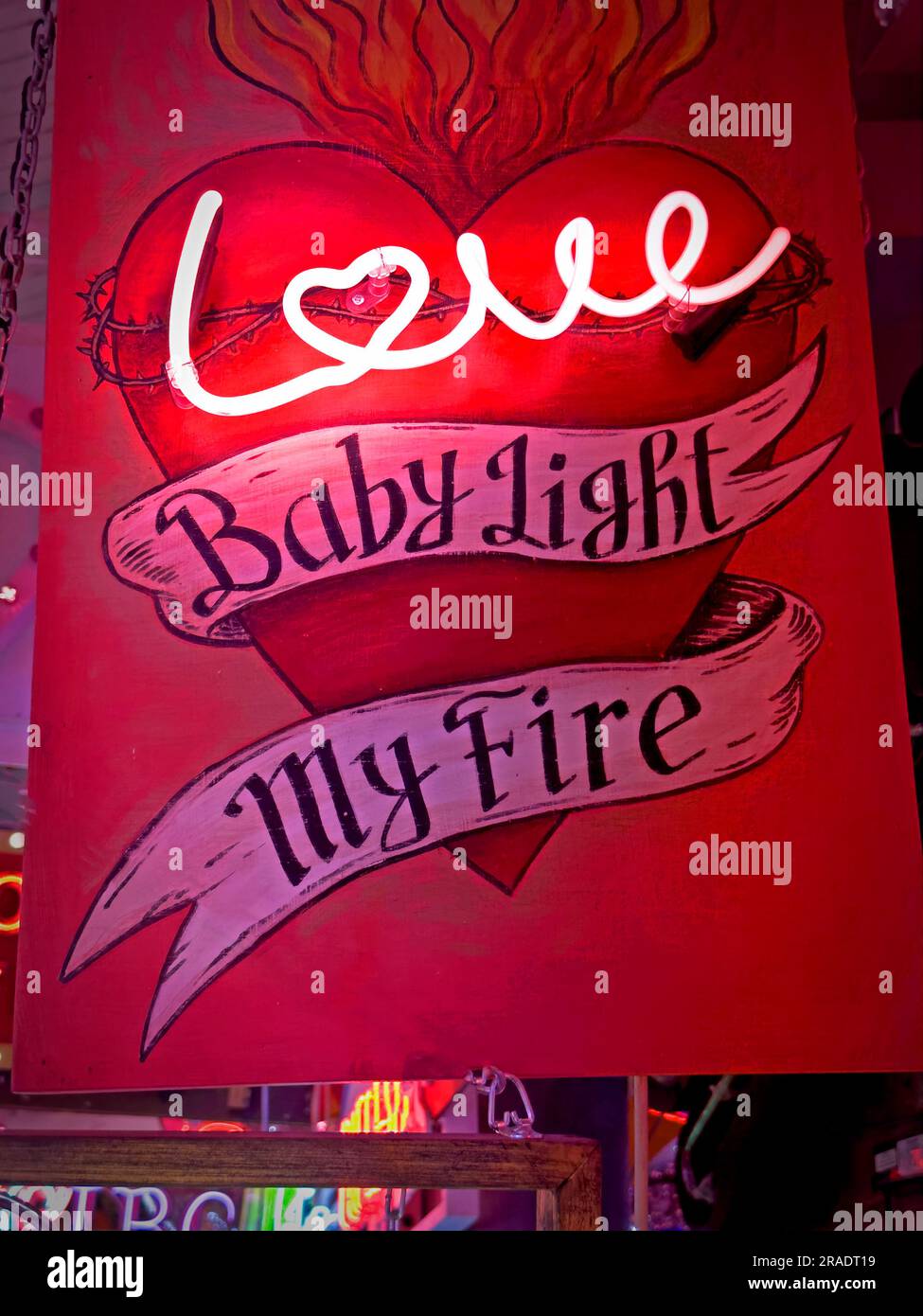 Love - baby it lights my fire, neon on a red background Stock Photo