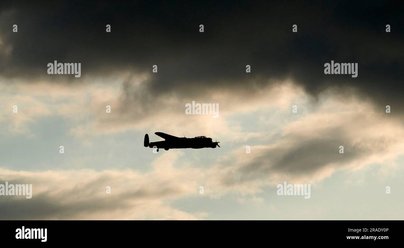 Battle of Britain Memorial flight, Lancaster Aircraft, shot over humberside, UK, silhouetted against dark clouds Stock Photo