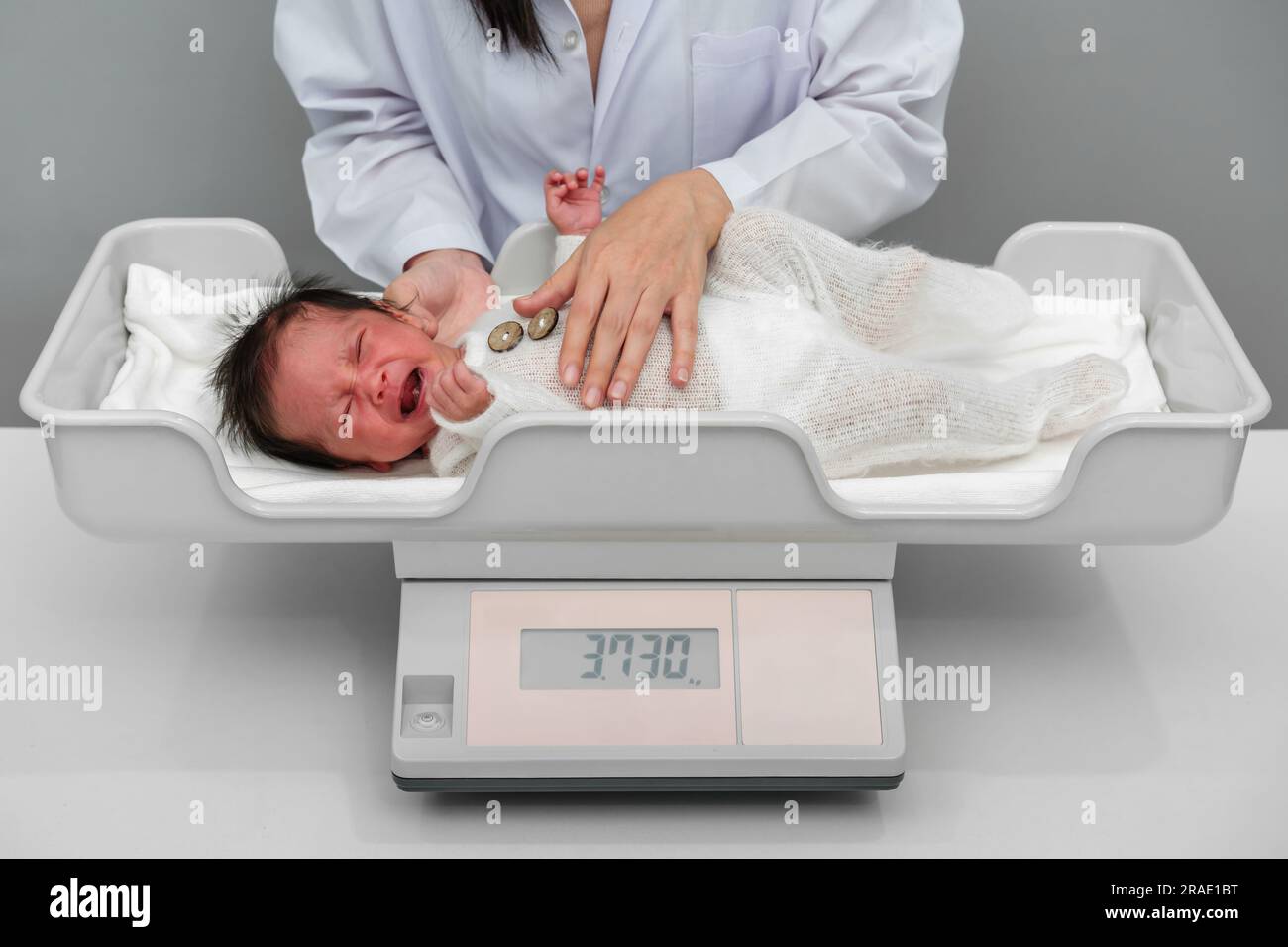 https://c8.alamy.com/comp/2RAE1BT/crying-newborn-baby-weight-measurement-on-the-digital-scales-with-doctor-in-hospital-2RAE1BT.jpg