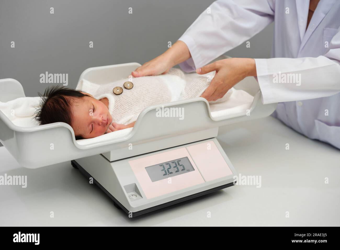 https://c8.alamy.com/comp/2RAE3J5/newborn-baby-weight-measurement-on-the-digital-scales-with-doctor-in-hospital-2RAE3J5.jpg