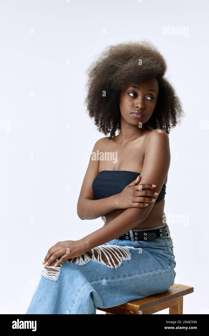 Portrait of beautiful, young, african woman with curly hair posing in ...