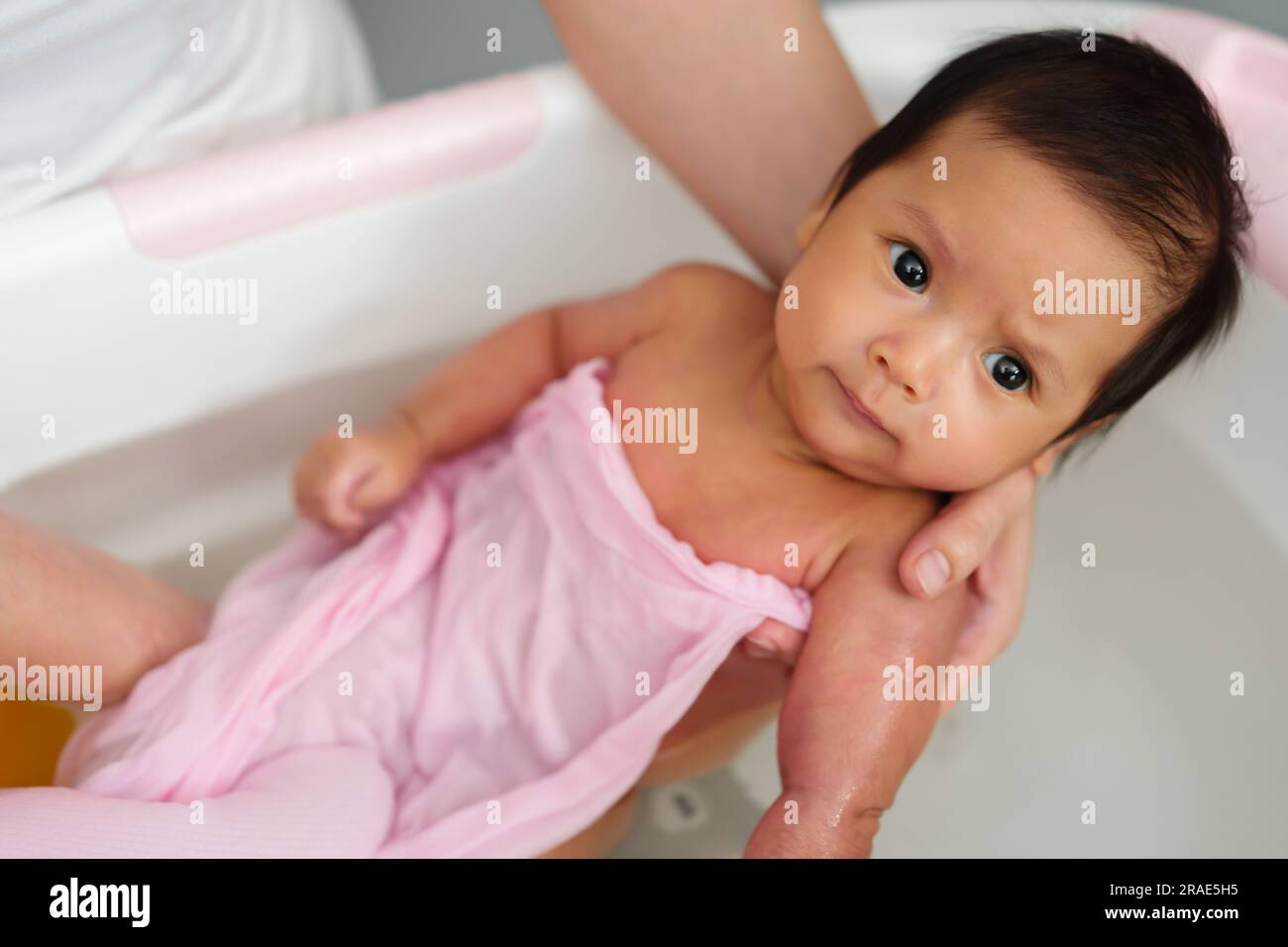 mother give a bath newborn baby in a bathtub Stock Photo Alamy