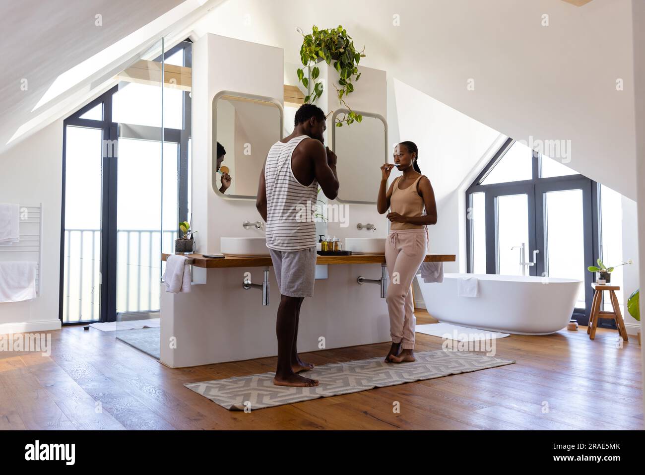 African american couple brushing teeth in bathroom Stock Photo