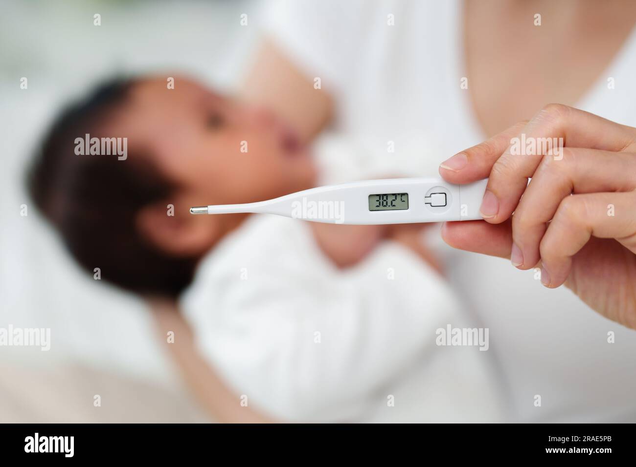 mother measuring temperature of her ill baby. sick child with high