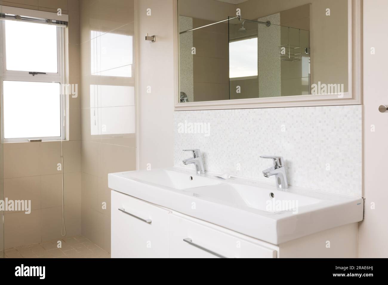 General view of bright bathroom with shower, mirror and washbasin Stock Photo