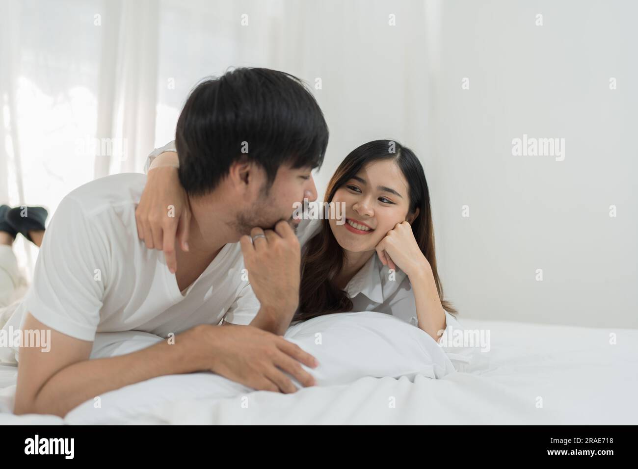 Asian Romantic couple in bed enjoying sensual foreplay Happy sensual young  couple lying in bed together. Beautiful loving couple kissing in bed Stock  Photo - Alamy
