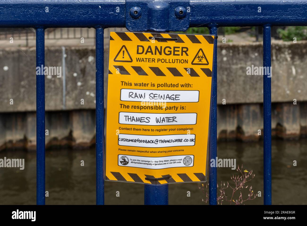 Protest sign reading Danger water pollution, this water is polluted with raw sewage. The responsible party is Thames Water. River Wey, Guildford, UK Stock Photo