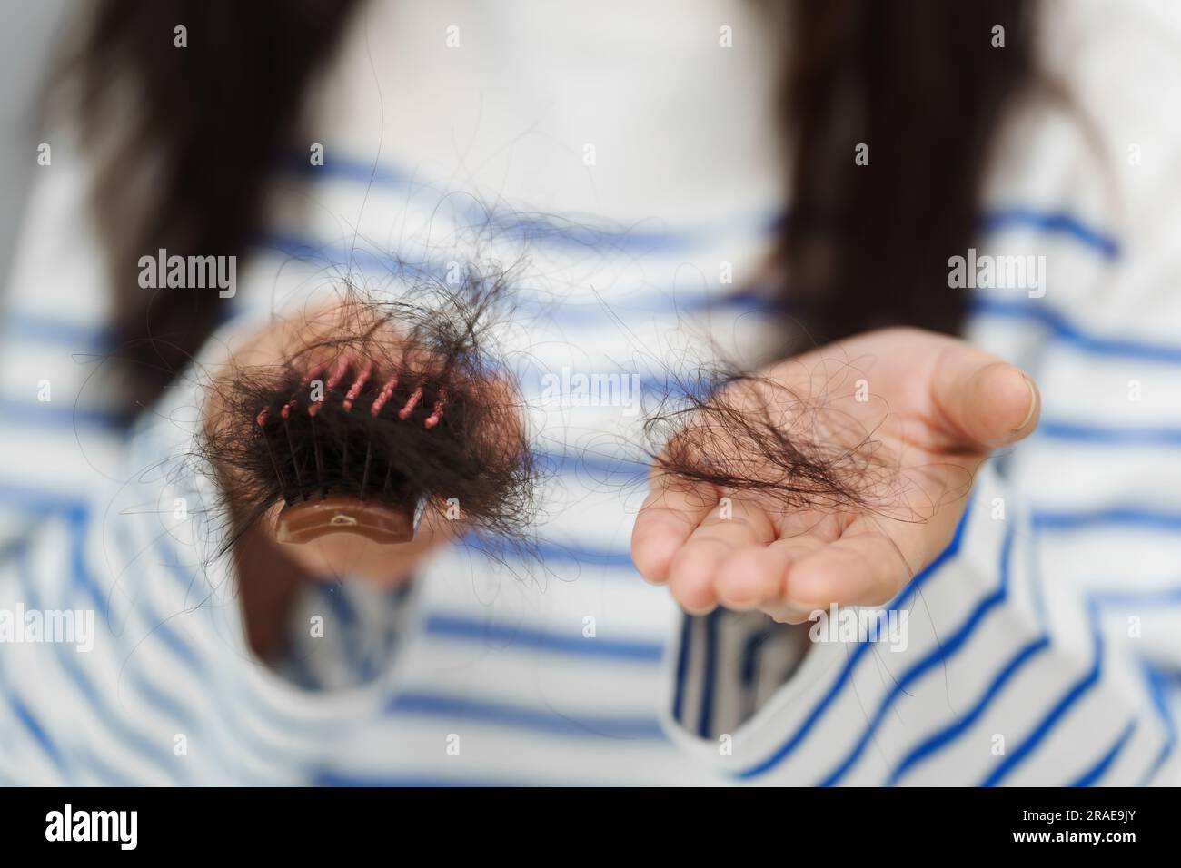 close up woman having hair loss problem with her hairbrush Stock Photo