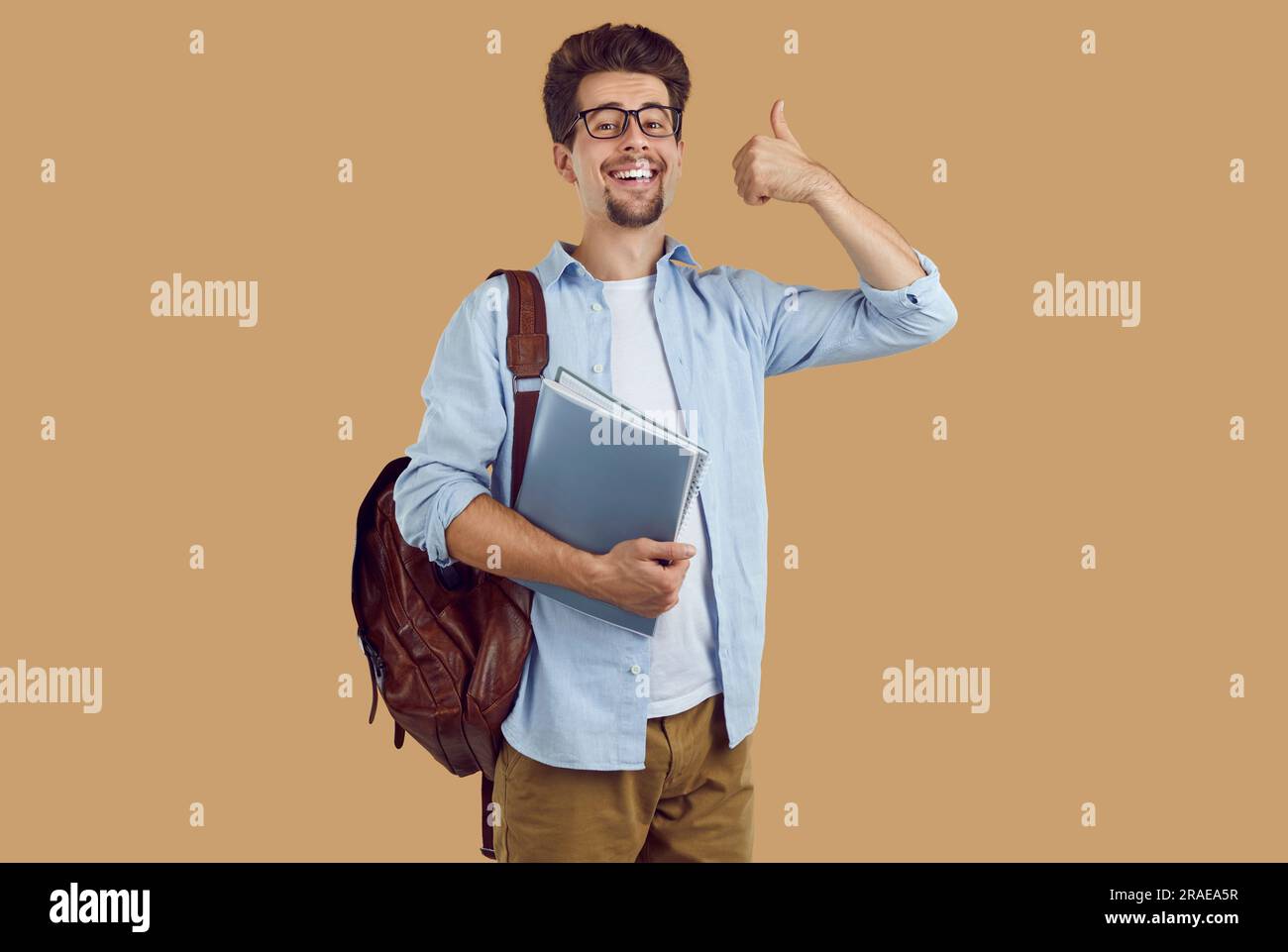 Happy man student with backpack showing thumbs up Stock Photo