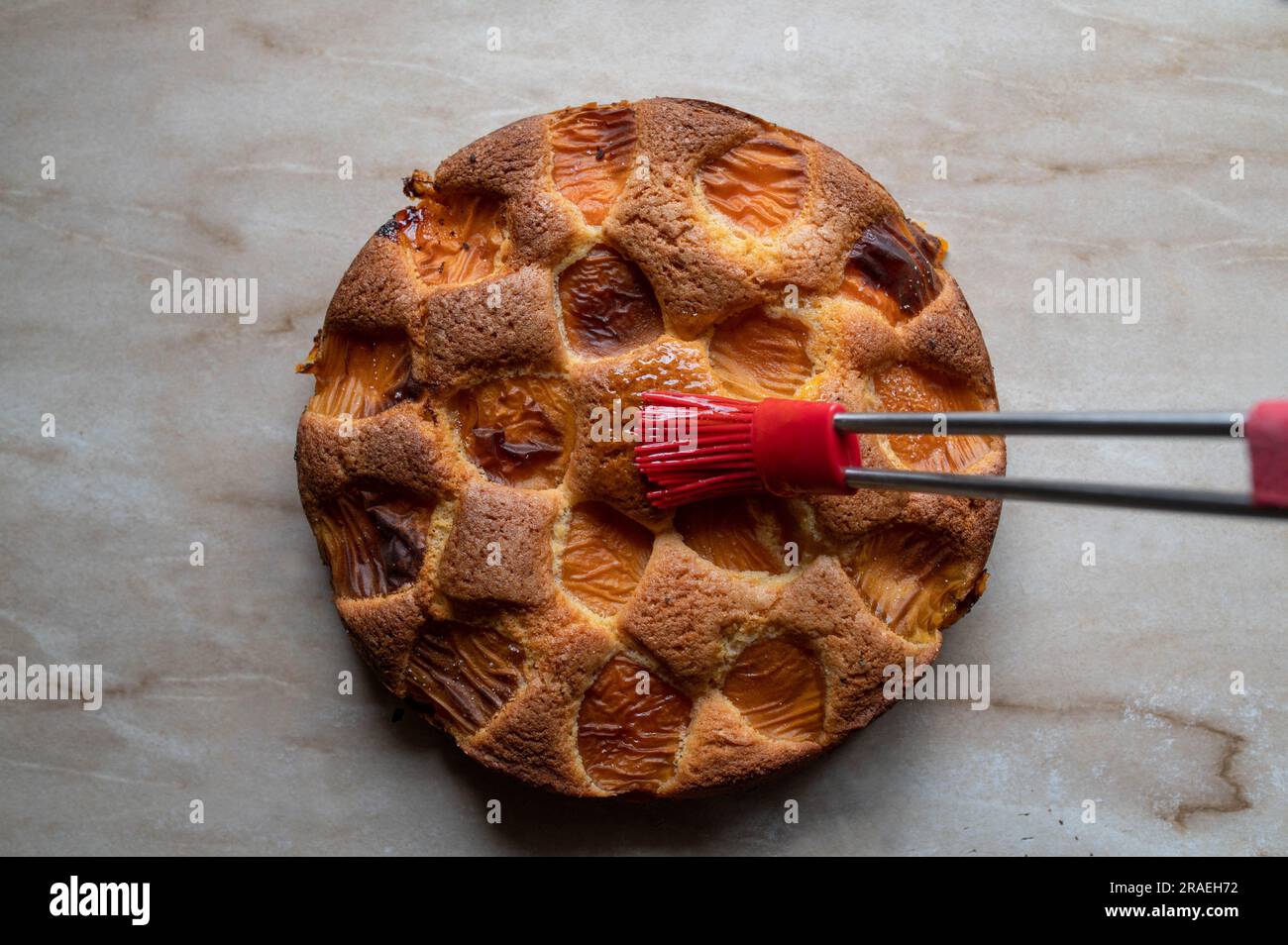 Cake is glazed with apricot jam with a brush Stock Photo