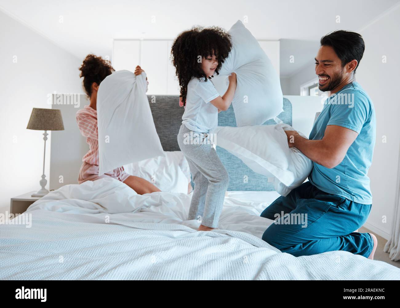 Happy family, pillow fight and playing on bed in the morning together for  fun bonding at home. Father, mother and playful children enjoying game  Stock Photo - Alamy