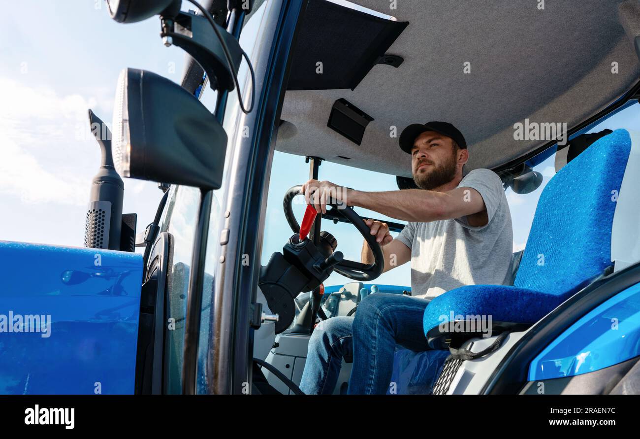 Tractor driver in sitting in agriculture tractor cabin Stock Photo Alamy