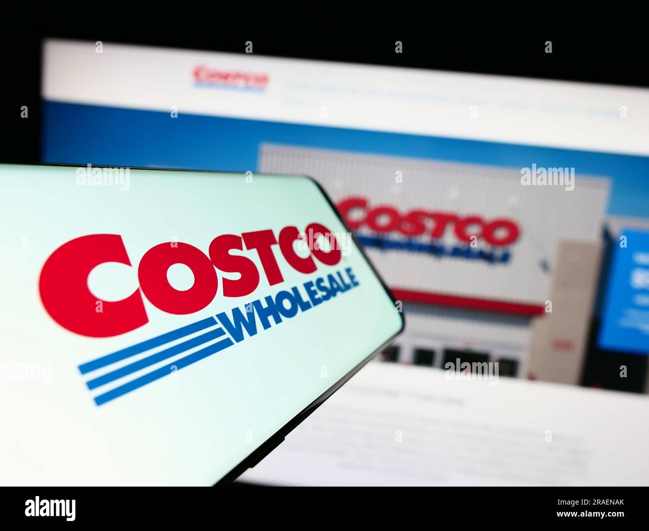 Smartphone with logo of American company Costco Wholesale Corporation on screen in front of website. Focus on center-left of phone display. Stock Photo