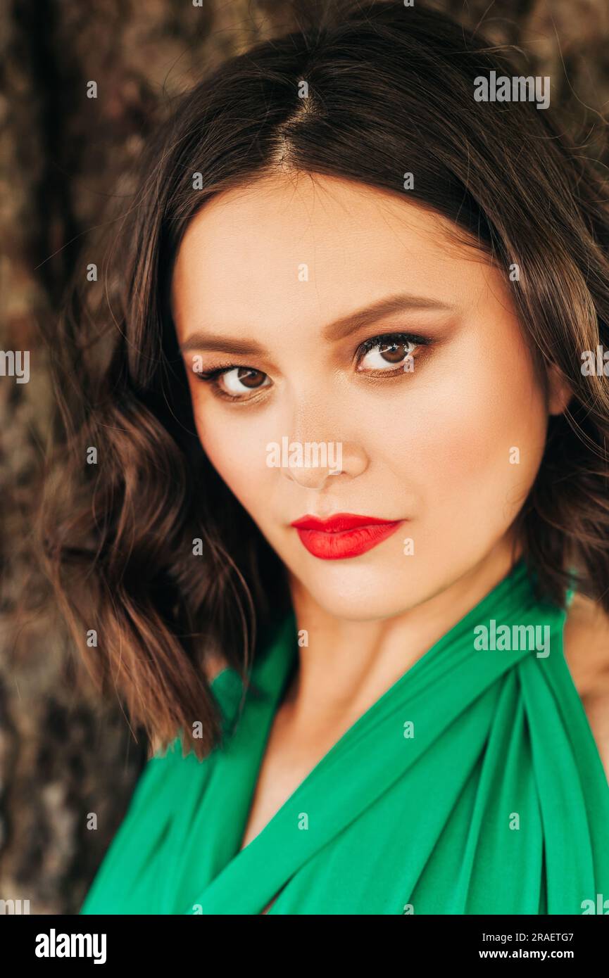 Close up portrait of beautiful young woman wearing green dress, red lips,  smokey eyes, beauty and fashion Stock Photo - Alamy