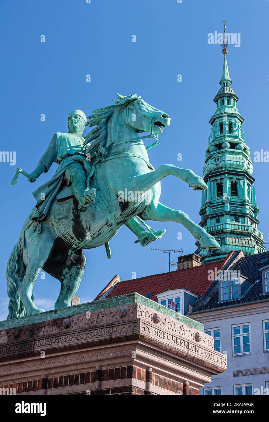 Copenhagen, Denmark - September 15, 2010: Equestrian statue of Absalon closeup stands on Hojbro Plads under blue sky. Nikolaj Kunsthallen ex church to Stock Photo