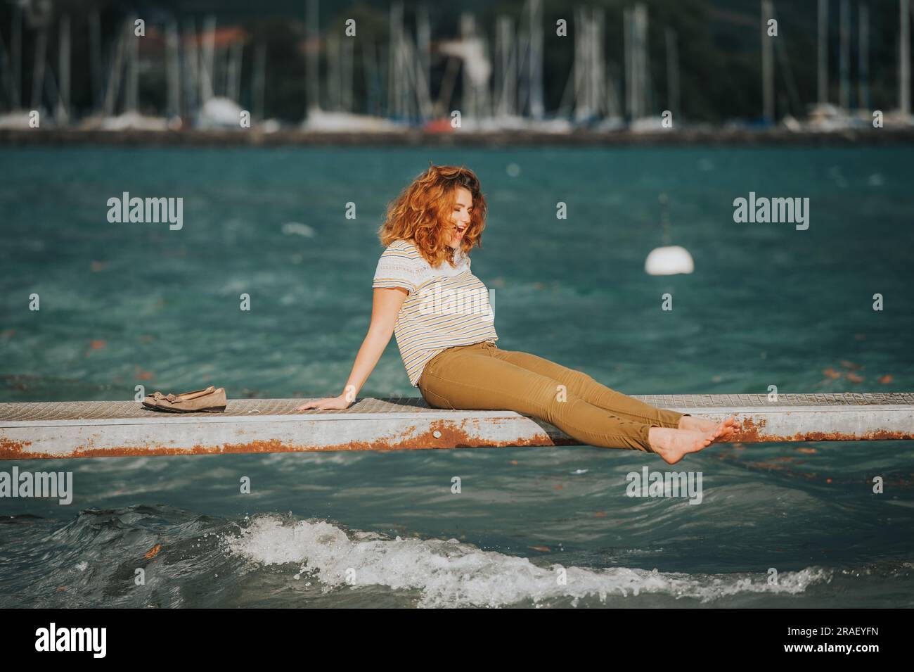 Young happy woman relaxing on the lake side on a srormy day Stock Photo