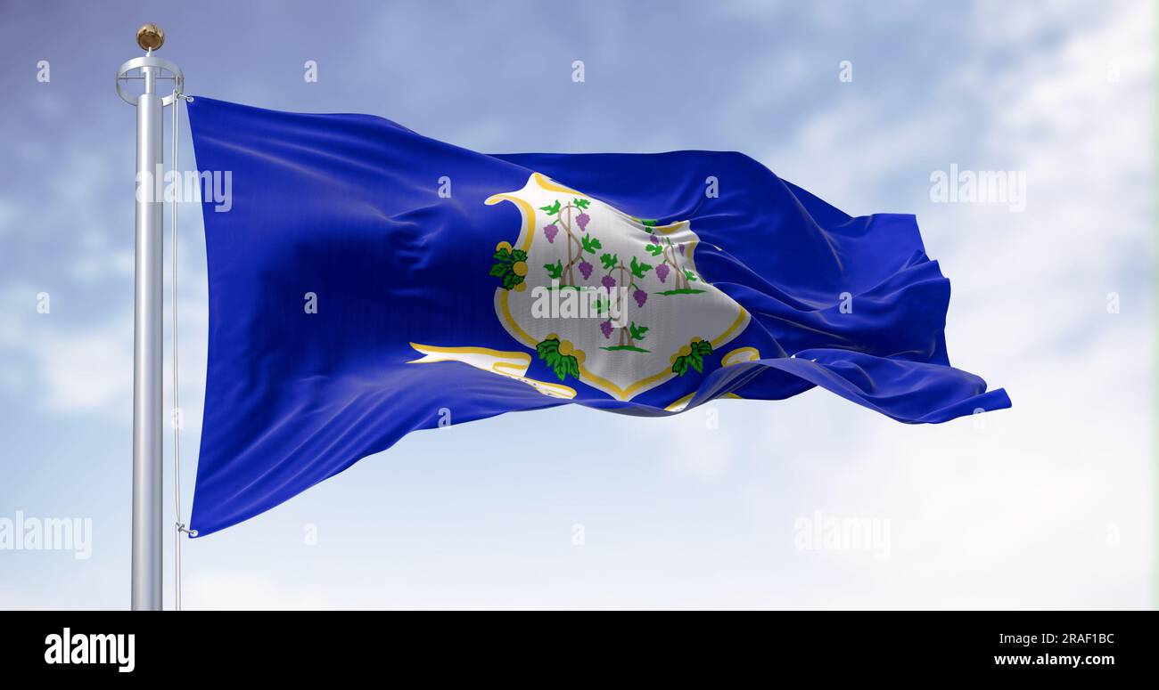 The Connecticut state flag waving on a clear day. White shield on blue background featuring three grapevines each bearing bunches of grapes. Textured Stock Photo