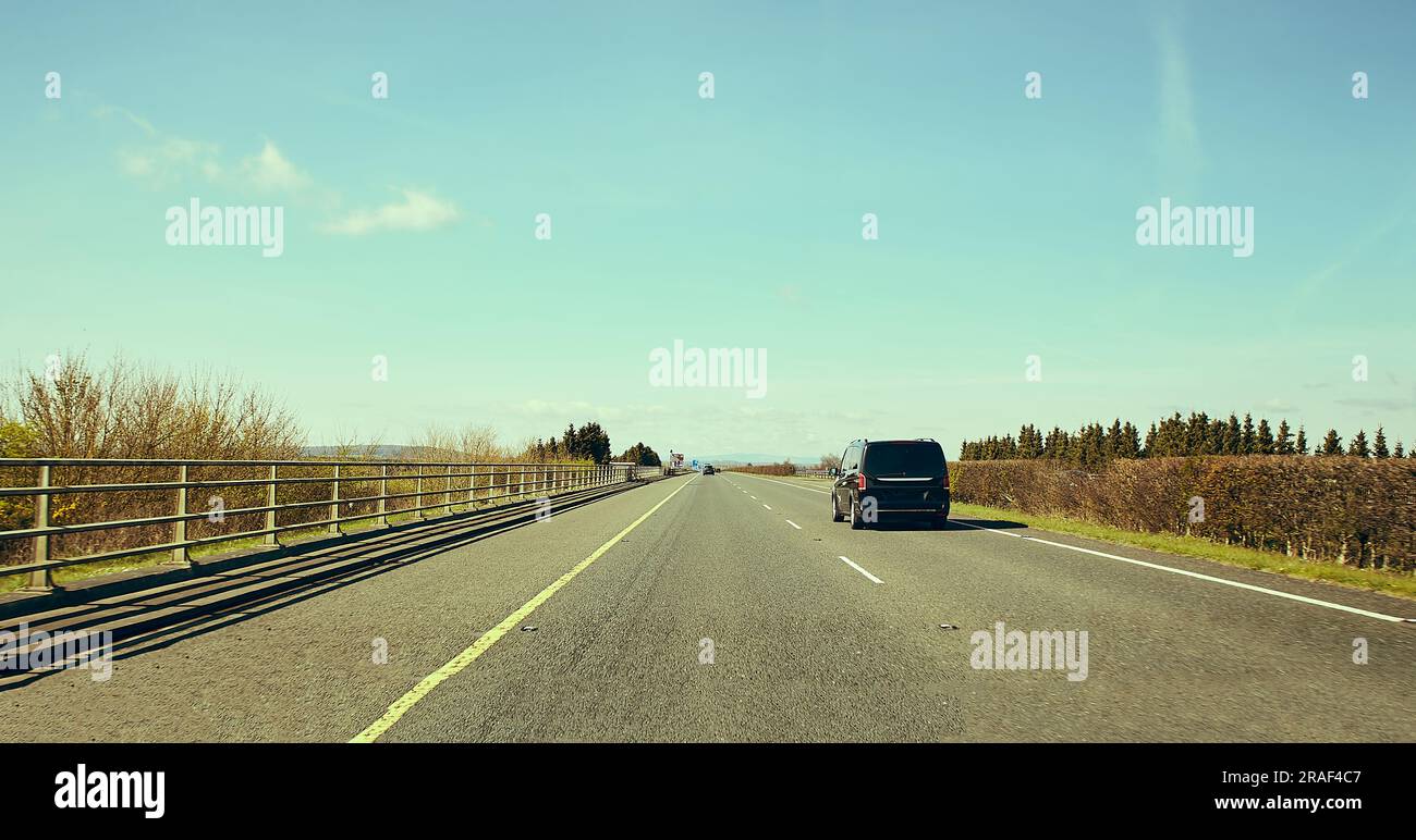 Rear view of cars driving on motorway, Ireland. Road with metal safety ...