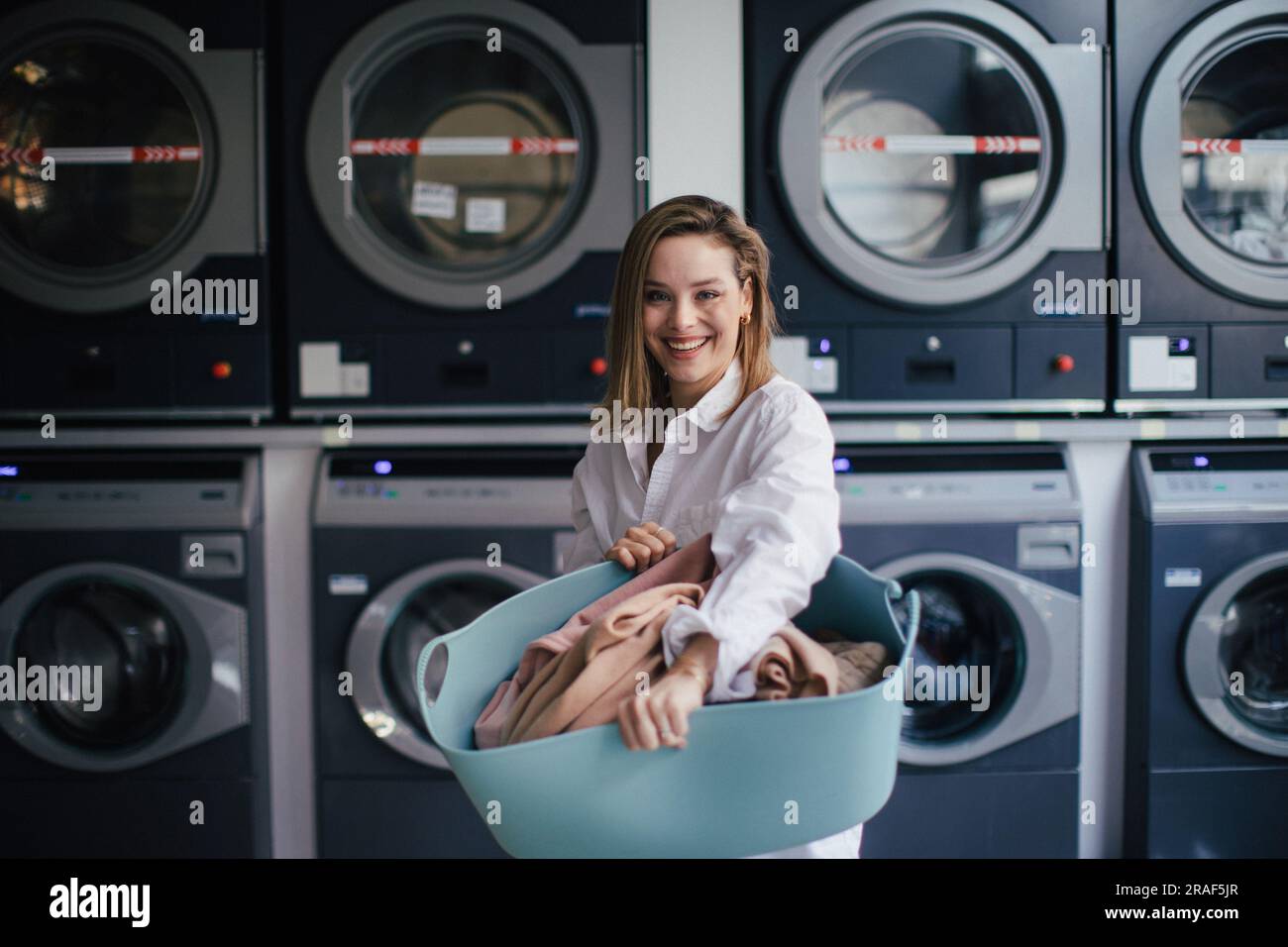 Young woman posing in a laundry room. Stock Photo