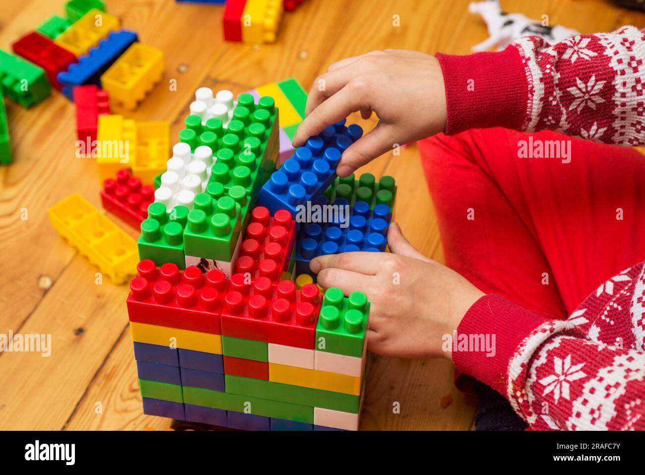A kid is having fun and building out of bright constructor bricks Stock ...