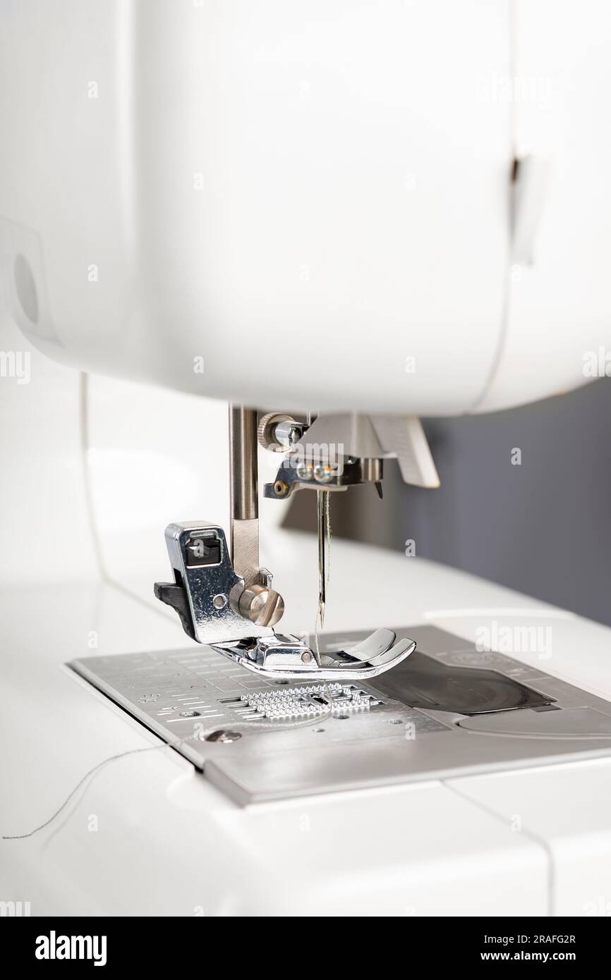 Modern white sewing machine presser foot closeup, macro. Sewing