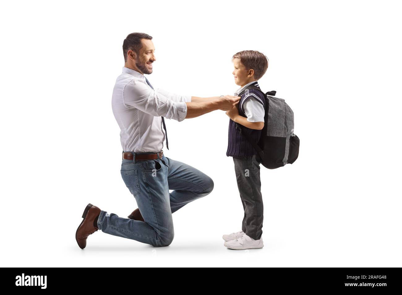 Full length profile shot of a father helping his son getting ready for school isolated on white background Stock Photo