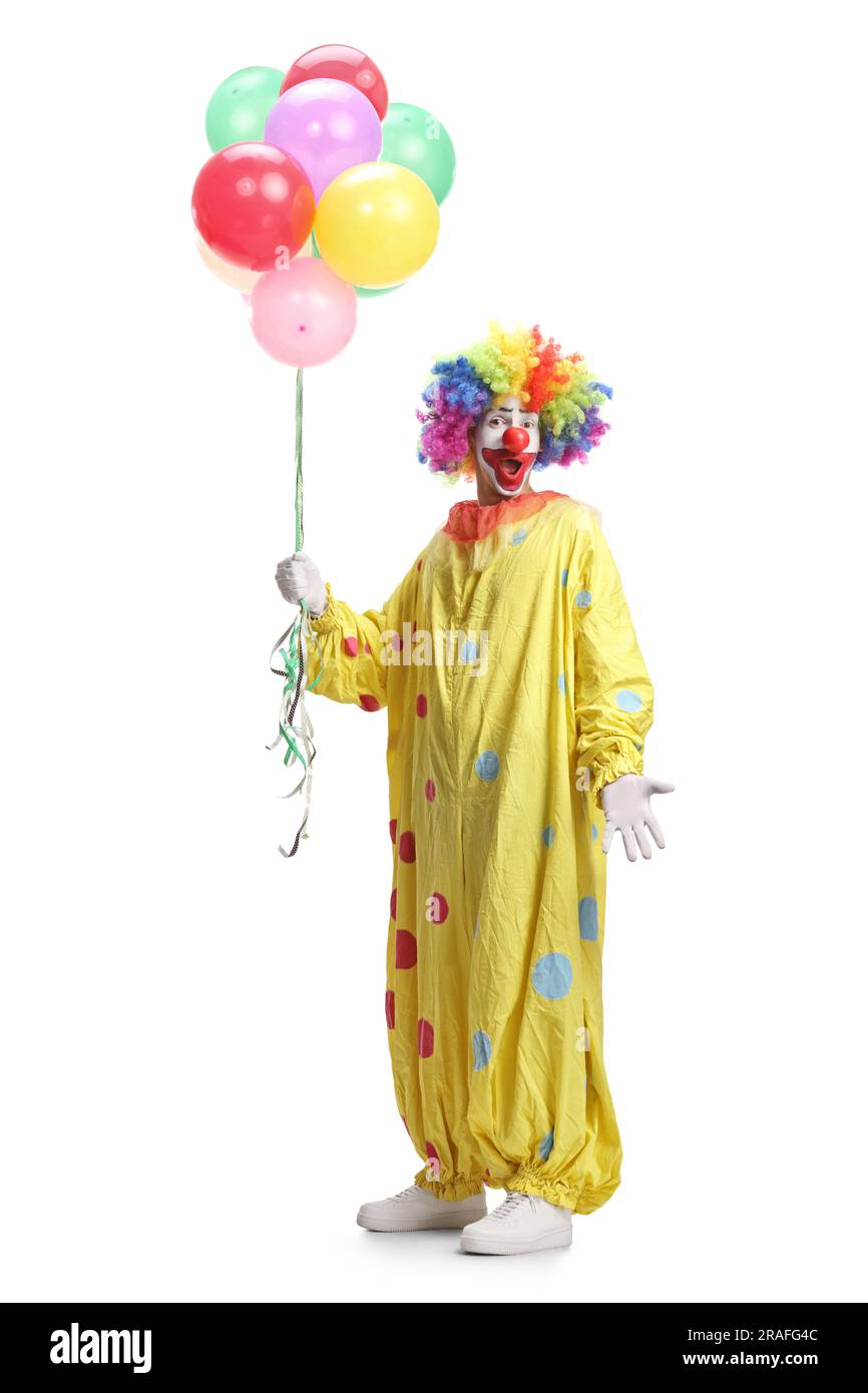 Full length portrait of a clown in yellow costume holding balloons ...