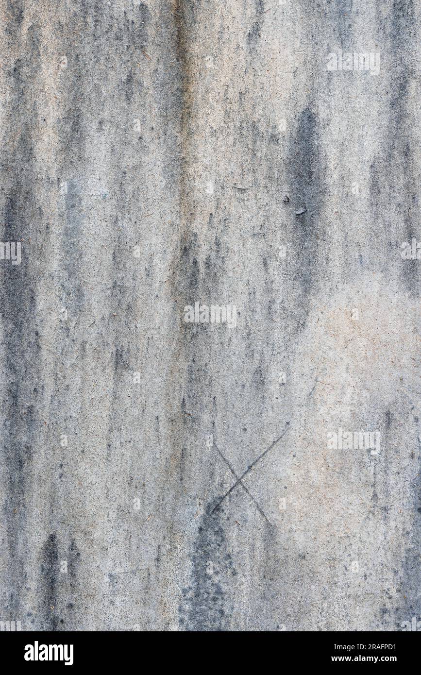 Gray cardboard surface texture background with blurry dirty dark spots and a scratched cross at the bottom. Vertical image. Copy space. Stock Photo