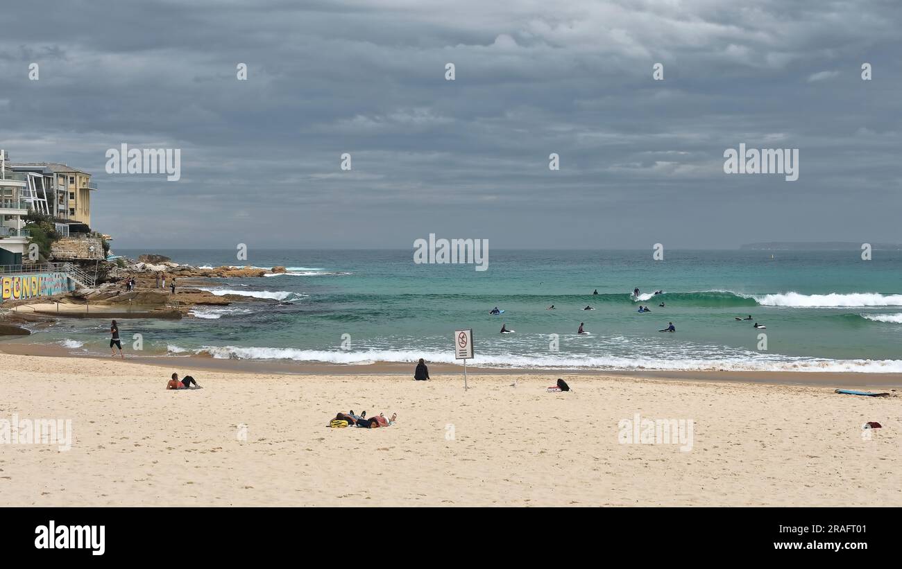 732 Beachgoers and surfers on North Bondi Beach end, under heavy ...