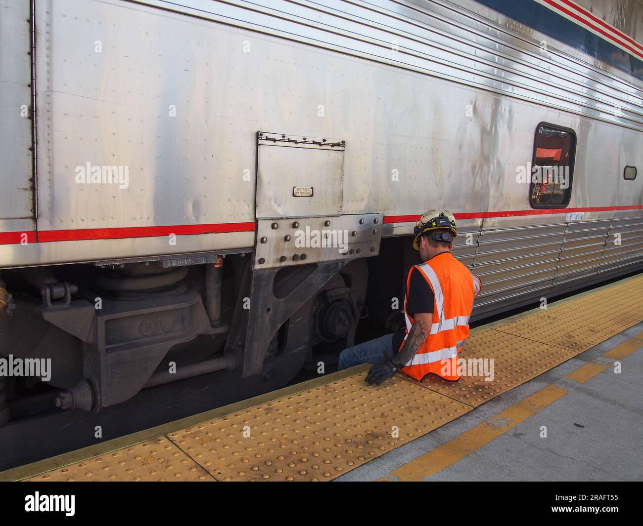Amtrak Auto-Train worker making a repair to a passenger car at the Lorton, Virginia, railway station, June 2, 2023, © Katharine Andriotis Stock Photo