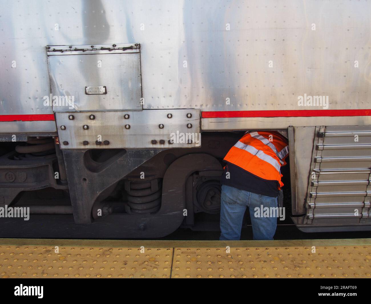 Amtrak Auto-Train worker making a repair to a passenger car at the Lorton, Virginia, railway station, June 2, 2023, © Katharine Andriotis Stock Photo