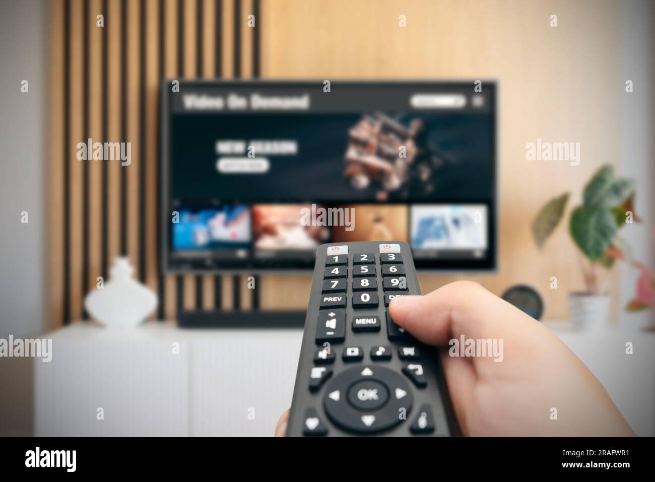 VOD service screen. Man watching TV with remote control in hand. Stock Photo