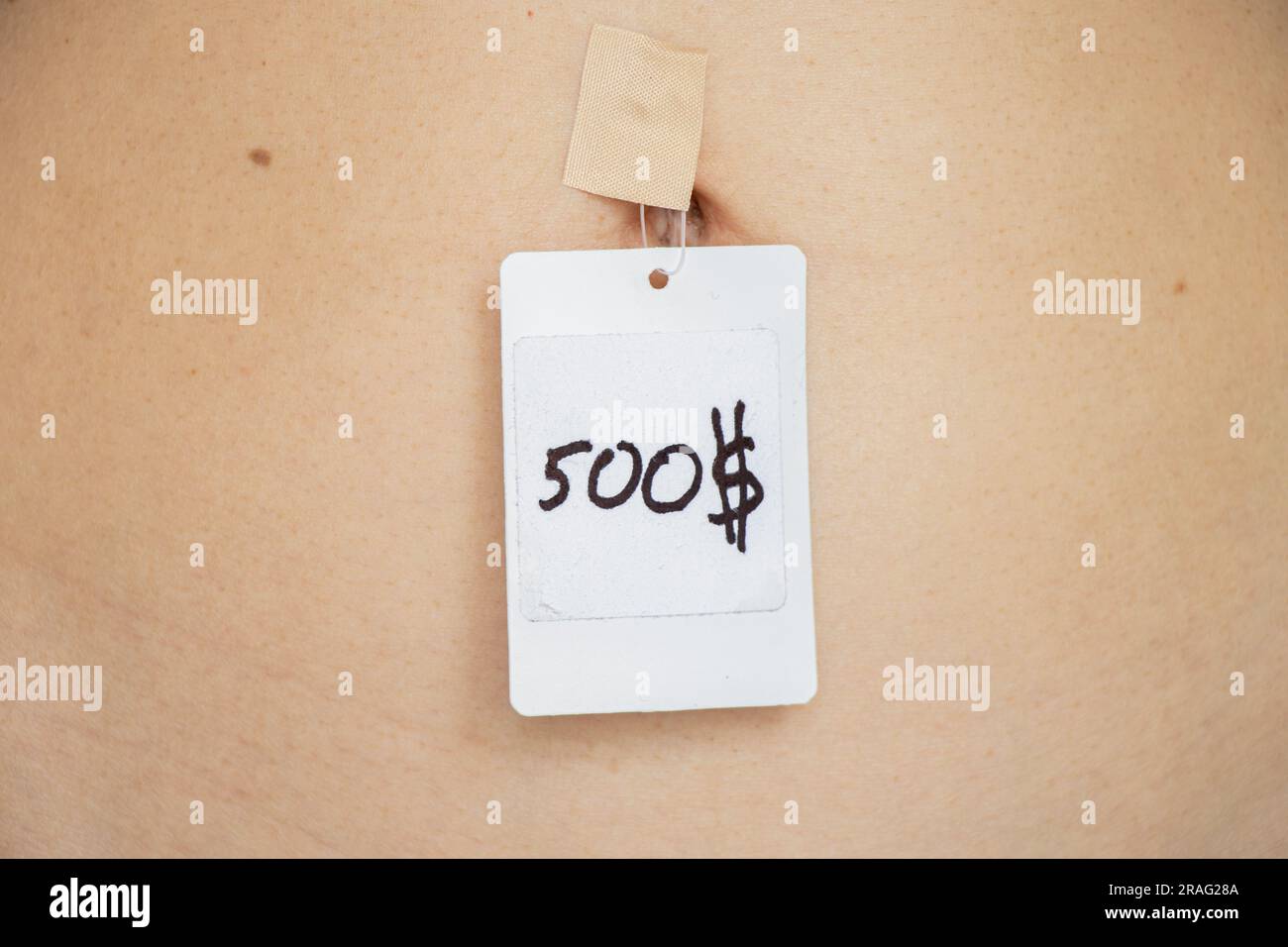 500 dollars price tag taped to girls belly, human trafficking, price per person, selling people Stock Photo