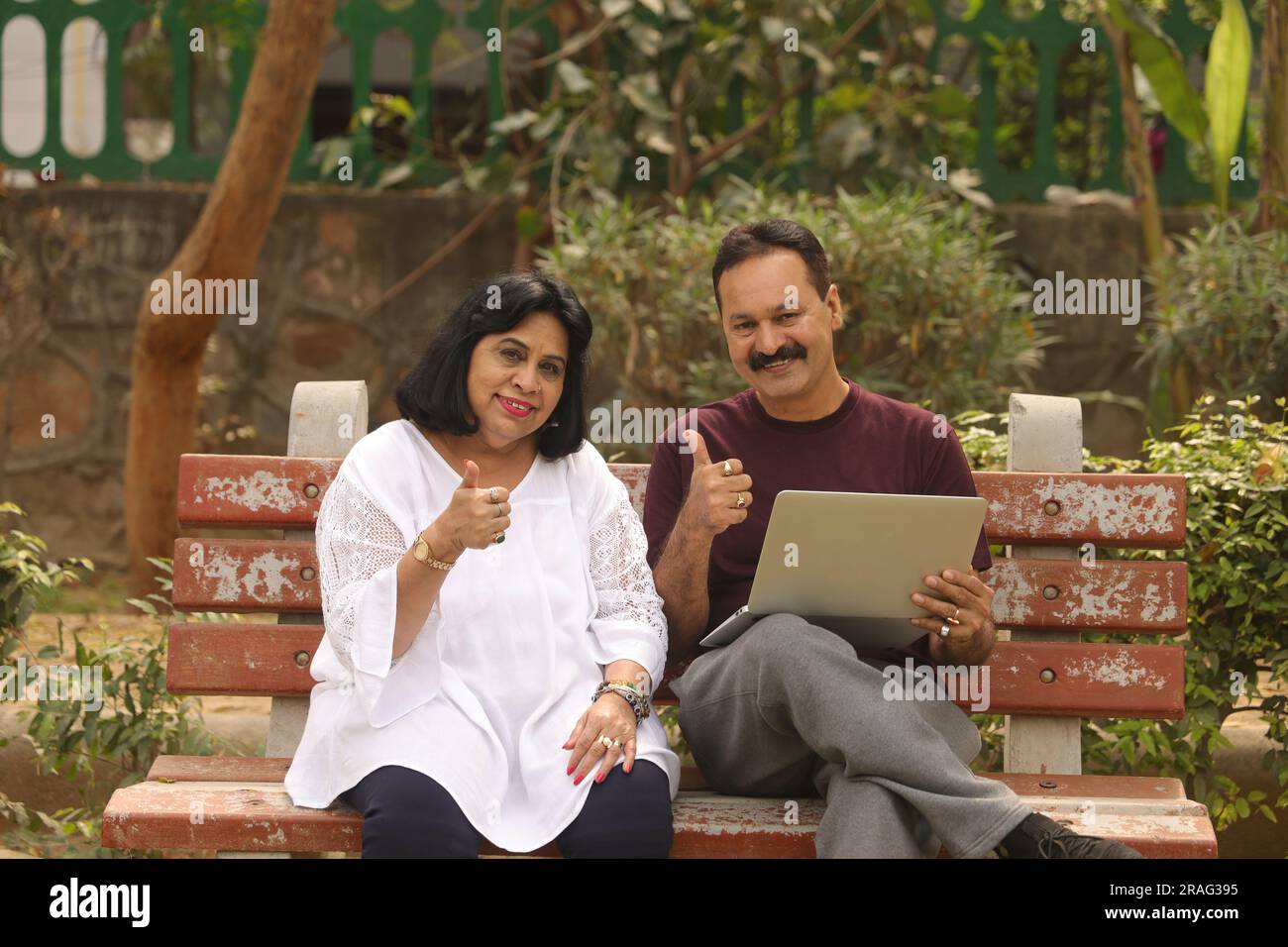 Beautiful Old Indian Happy couple sitting together in the park and having joyful moments of life. Planning for vacations together. Stock Photo