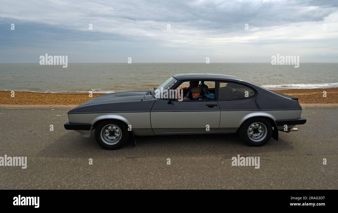 Classic Grey and Silver Ford Capri on seafront promenade ocean in background. Stock Photo