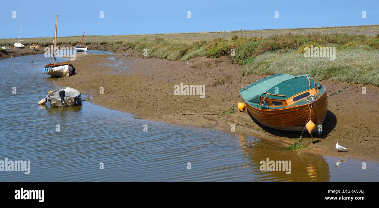 Tidal creek between at Morston Quay at low tide with boats Stock Photo
