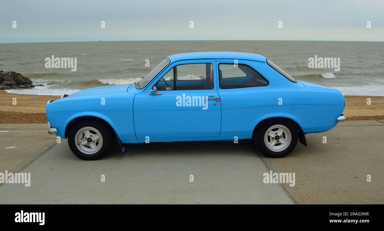 Classic  Light Blue Ford Escort Motor Car parked on seafront Promenade beach and sea in background. Stock Photo