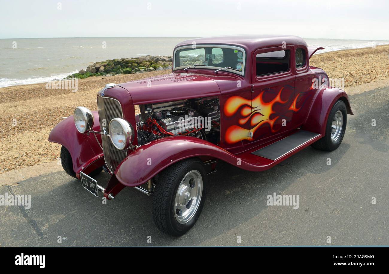 Classic Hot Rod  parked on seafront promenade  beach and sea in background. Stock Photo