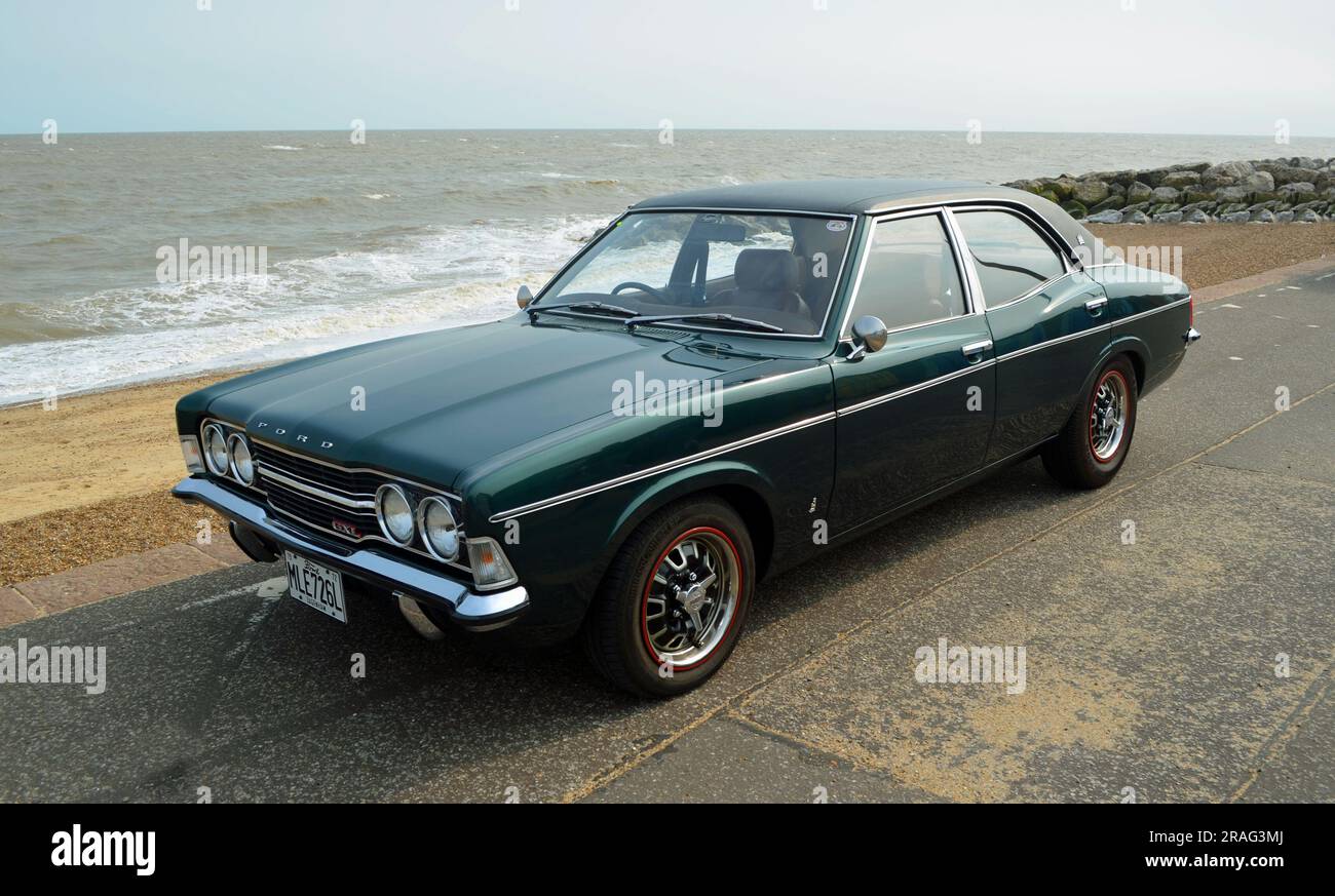 Classic Ford Cortina mark 3  parked on seafront promenade beach and sea in background. Stock Photo