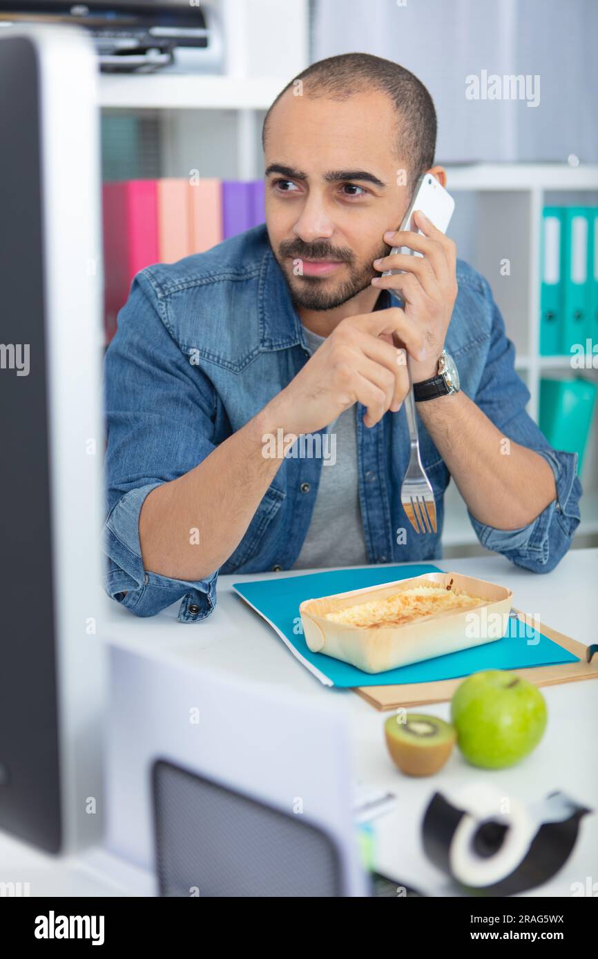 busy businessman eating lunch at the office desk Stock Photo Alamy
