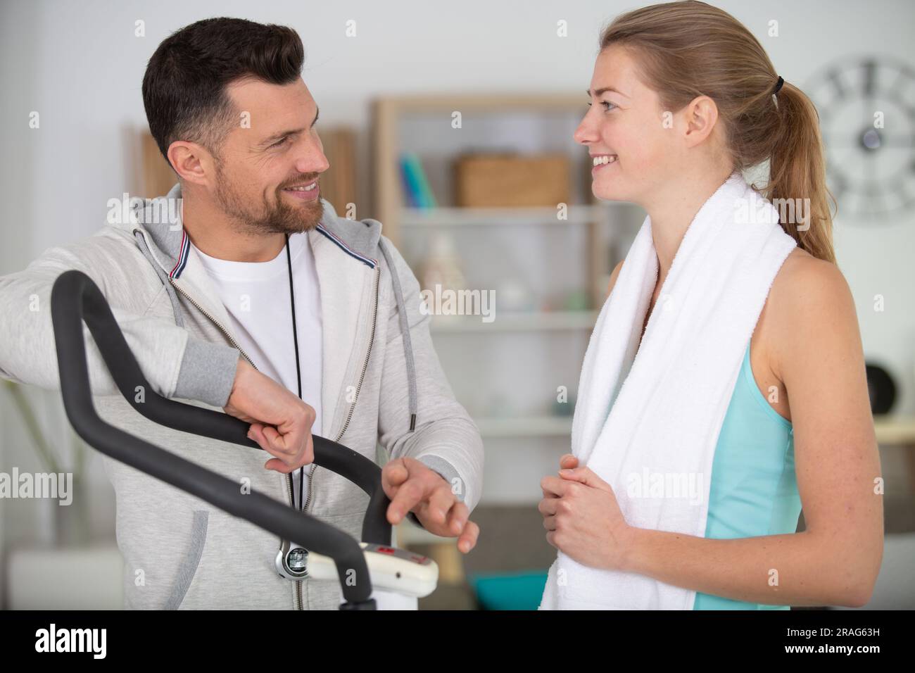 personal trainer explaining settings on exercise machine Stock Photo