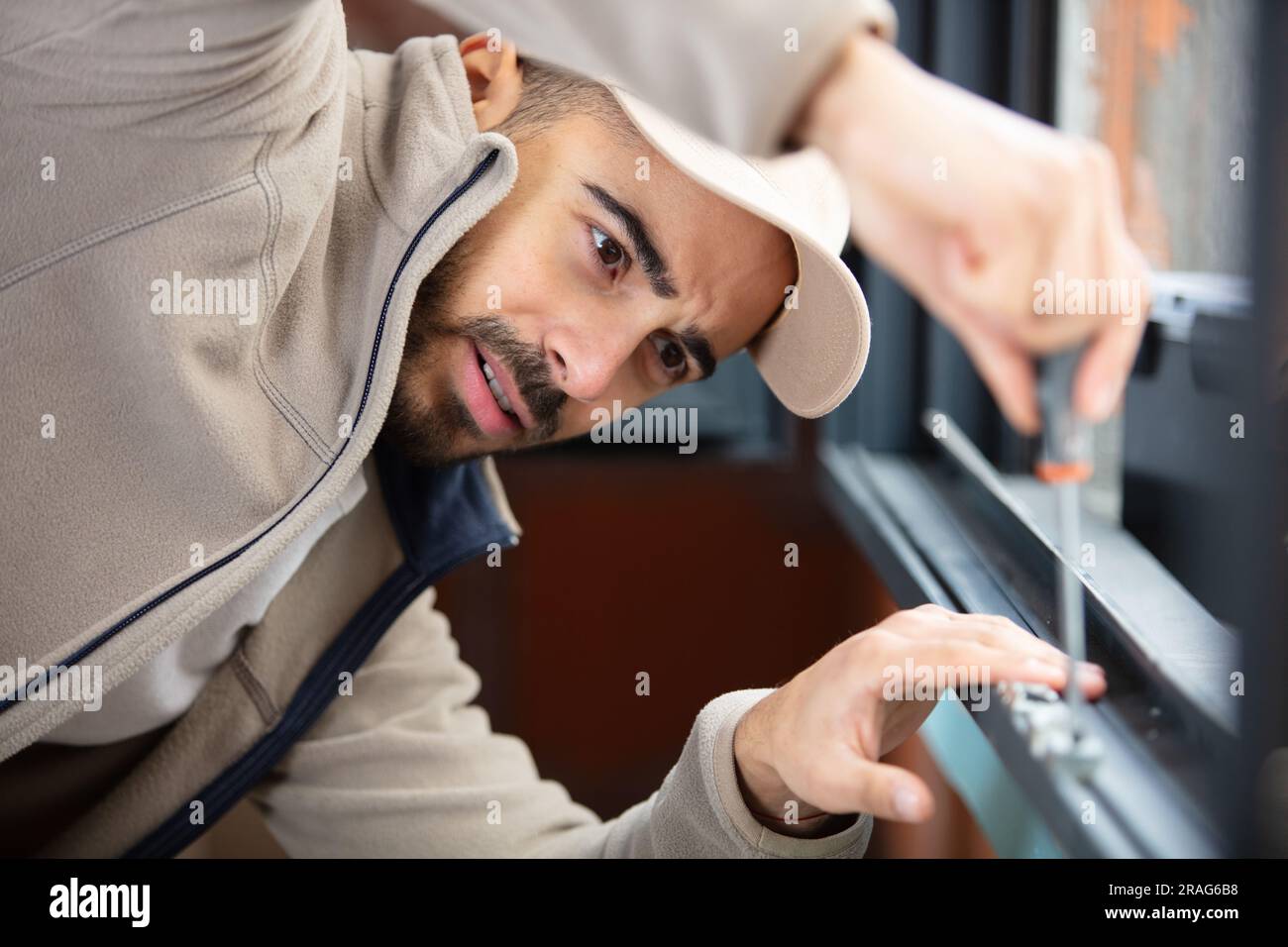 worker fasten the handle to a plastic window Stock Photo