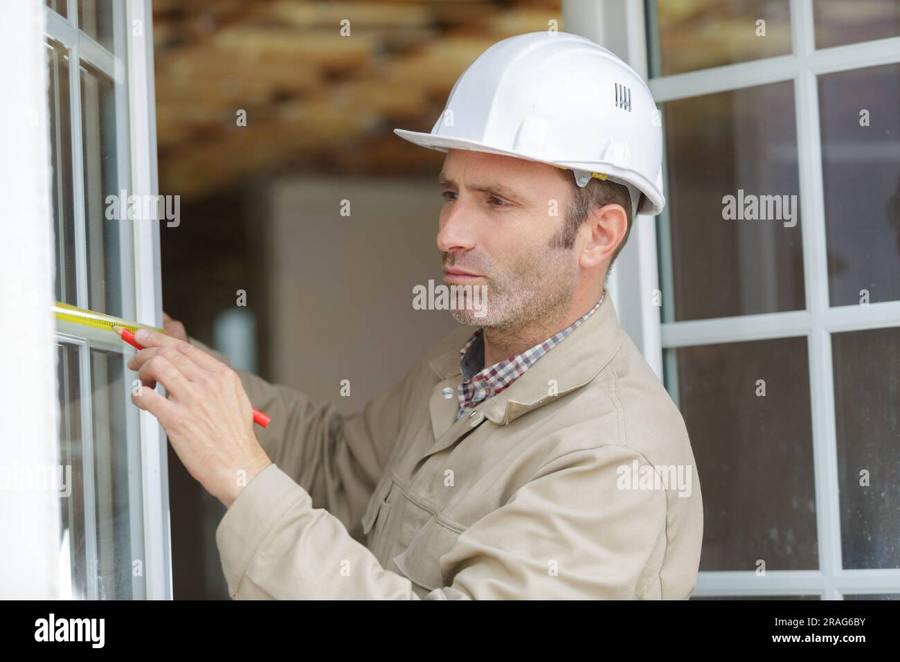 man measuring window prior to installation Stock Photo
